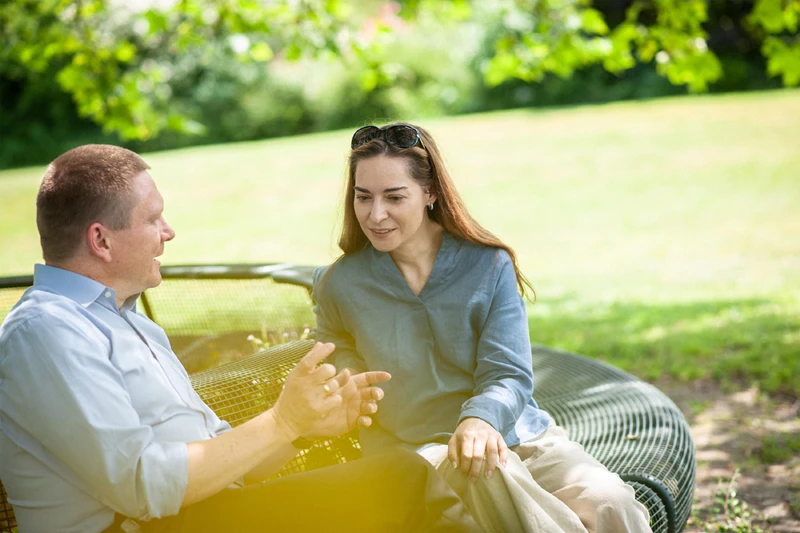 Zwei personen sitzen drau&szlig;en und unterhalten sich