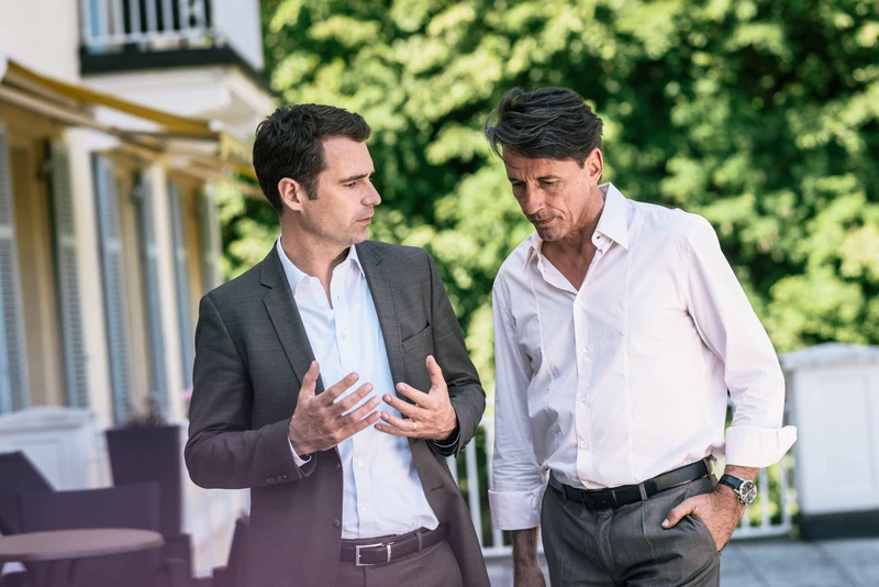 Zwei M&auml;nner stehen drau&szlig;en und reden