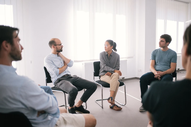 Therapie Gruppe sitzt zusammen in einem hellen wei&szlig;en raum